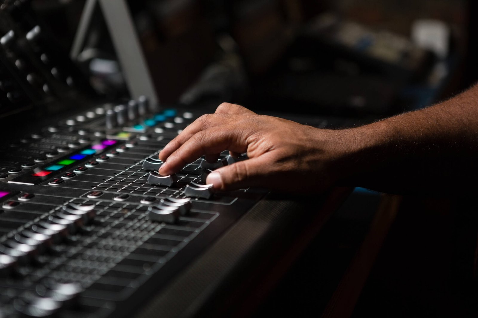 Hand of male audio engineer using sound mixer in recording studio